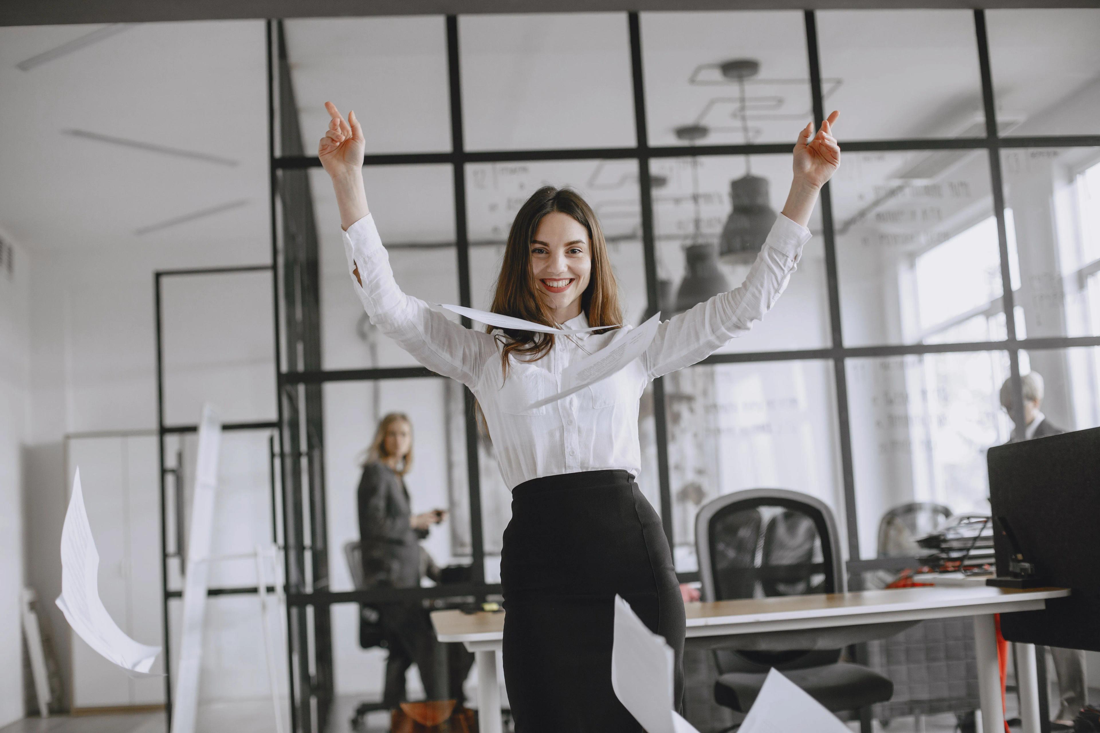 Woman smiles after throwing paper in the air
